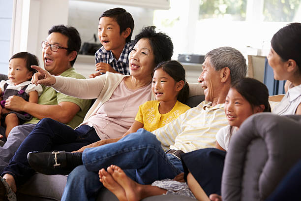 istock Extended Family Group At Home Watching TV Together 538045192