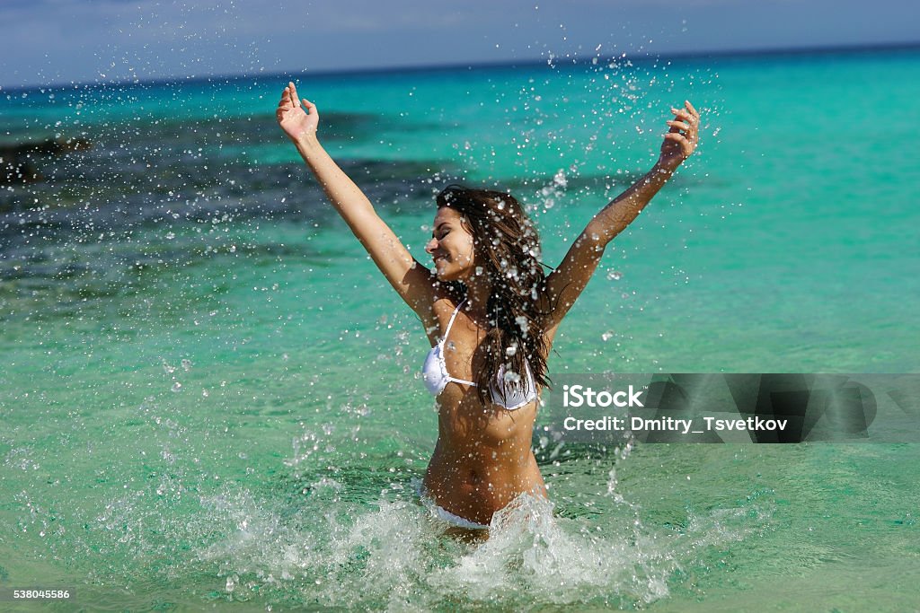 young woman have fun in water Young beautiful happy woman playing in blue water on a sunny day. Pretty girl enjoying vacation, sun and sea. Adult Stock Photo