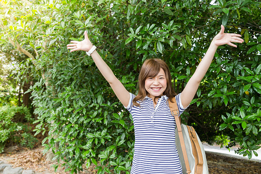 A young cute and cheerful Japanese girl posing for a photograph in front of the camera.