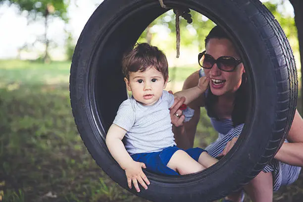 Mother and son on tire swing