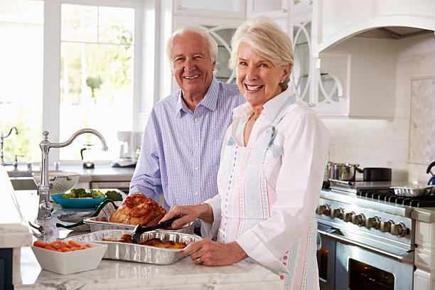 istock Senior Couple Make Roast Turkey Meal In Kitchen Together 538047136