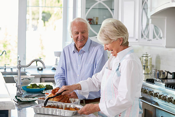 istock Senior Couple Make Roast Turkey Meal In Kitchen Together 538047174