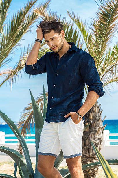 istock Young handsome tanned model posing under the palms 538047776