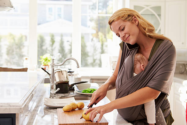 istock Busy Mother With Baby In Sling Multitasking At Home 538048106