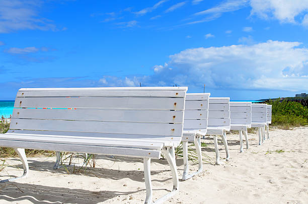 белый деревянный скамьи на белом песчаном пляже - beach bench caribbean sea cloudscape стоковые фото и изображения