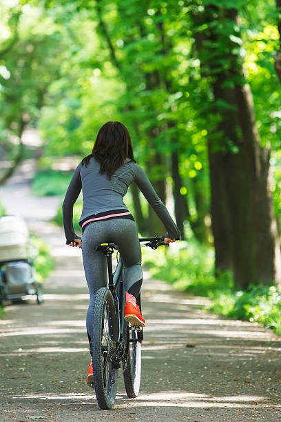 istock cyclist woman riding a bicycle in park 538049030