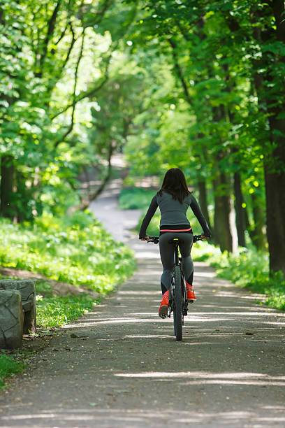 istock cyclist woman riding a bicycle in park 538049090