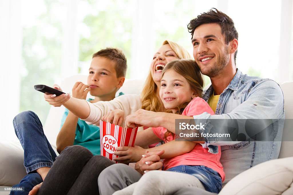 Family watching television in living room Family Stock Photo