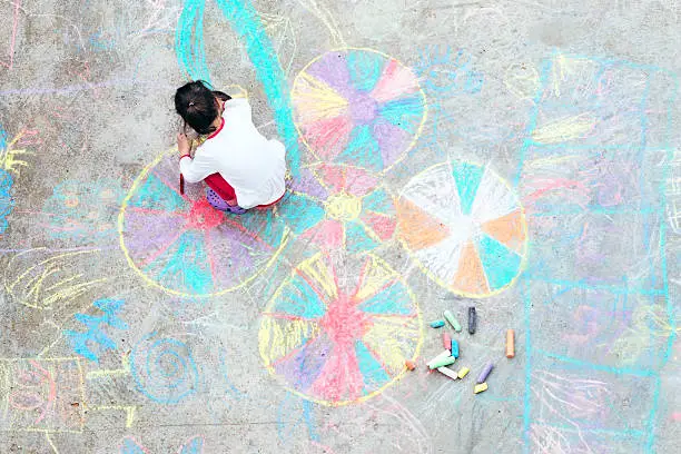 Photo of Young kid playing with chalk.