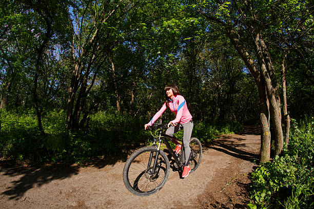 istock Young woman having fun riding a bicycle in the park. 538052388