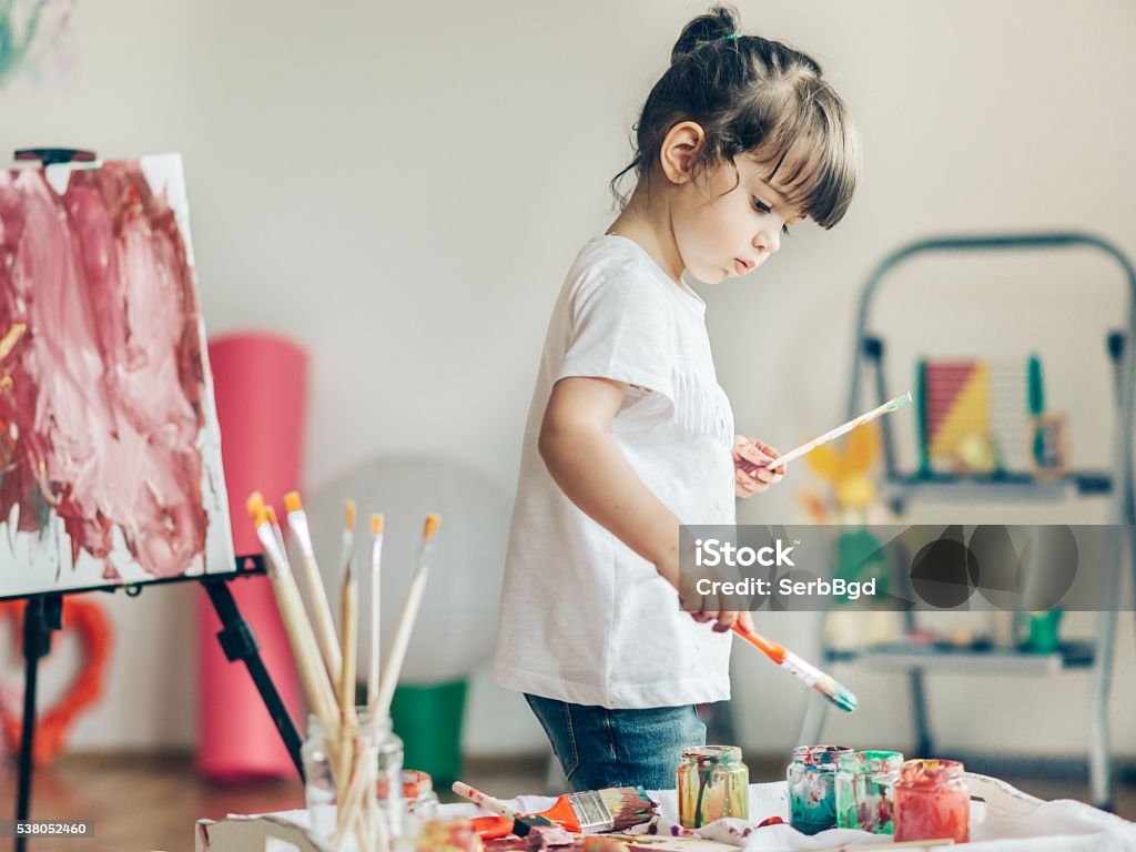 Cut girl painting in at her  home. Child Stock Photo