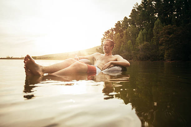 istock Young man in lake on inflatable ring 538052472
