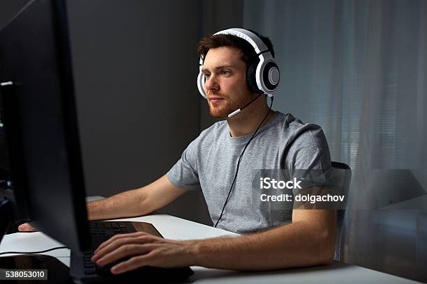 Man In Headset Playing Computer Video Game At Home Stock Photo - Download Image Now - Gamer, Men, Video Game