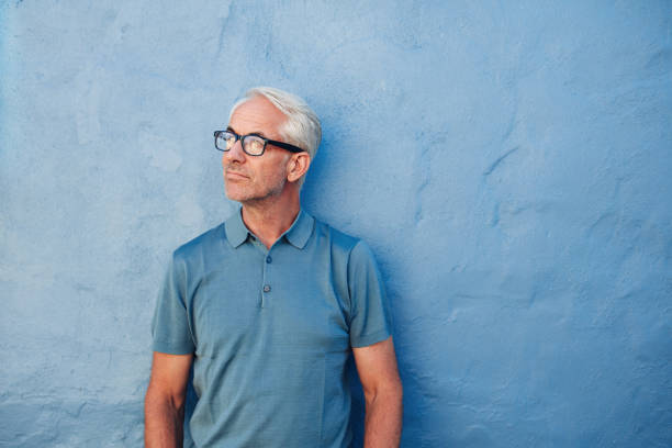 istock Pensive mature man standing against a blue wall 538053186