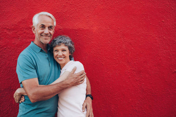 istock Affectionate mature couple together on red background 538053894