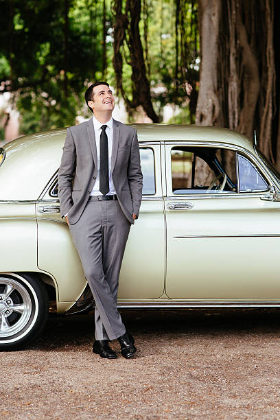 istock Young Hispanic groom standing next to classic car 538059456