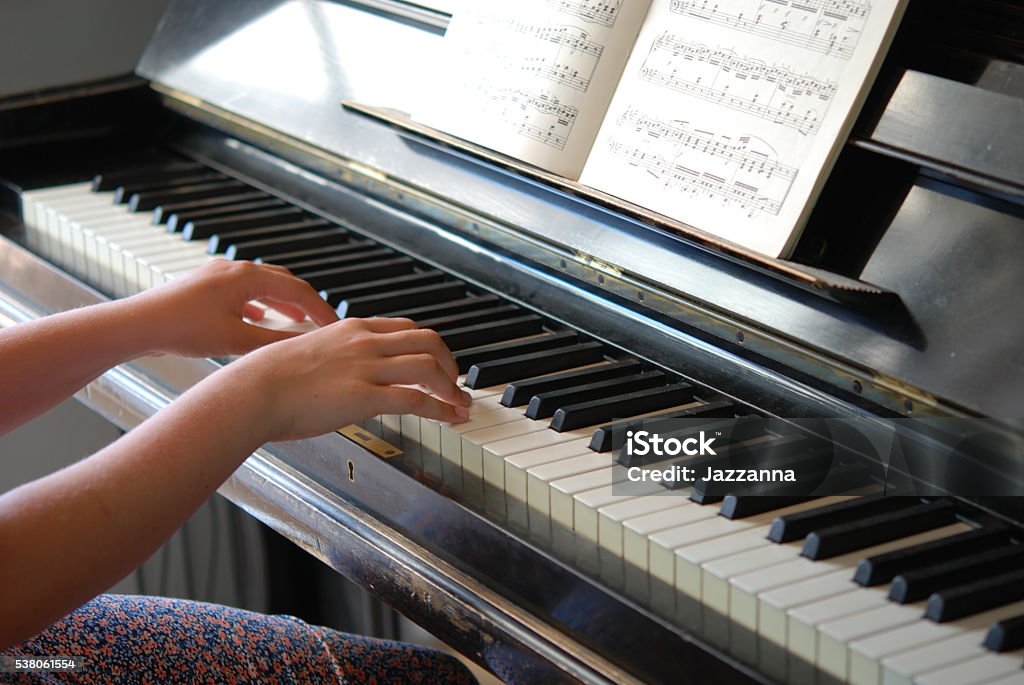 Girl playing the piano Girl playing the piano, learning to play Sheet Music Stock Photo