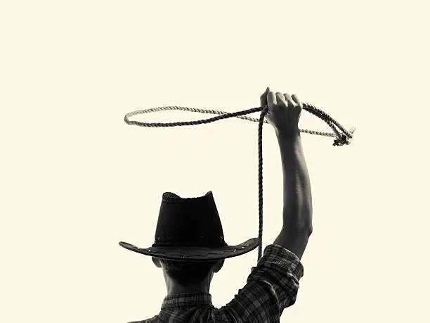 cowboy throws a lasso on the isolated background