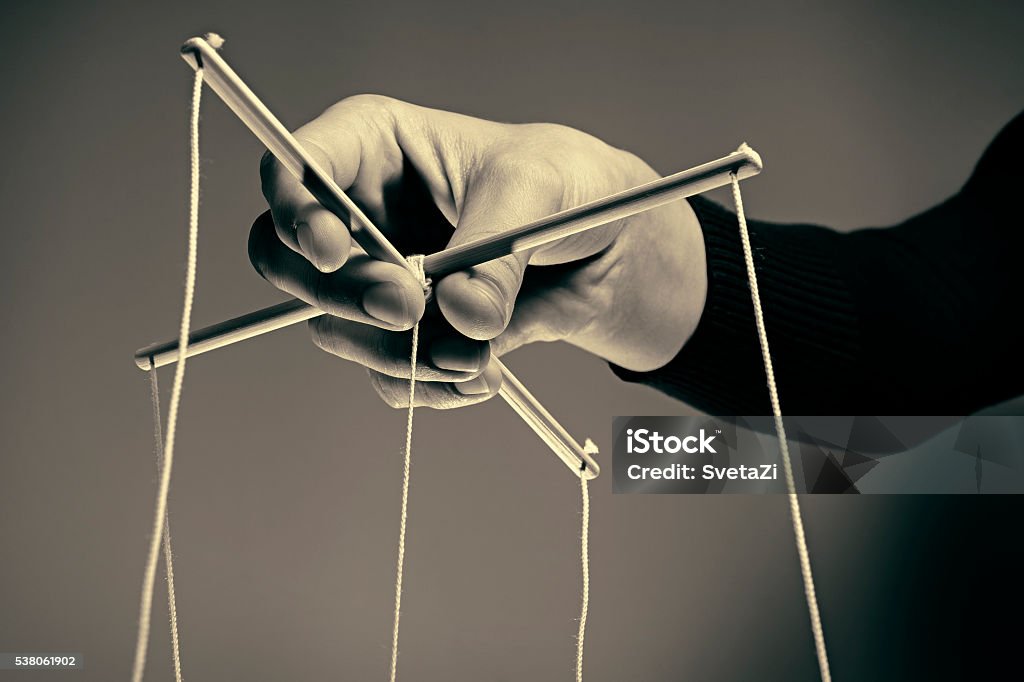 Manipulating arm Manipulating arm on a black and white  background Puppet Stock Photo