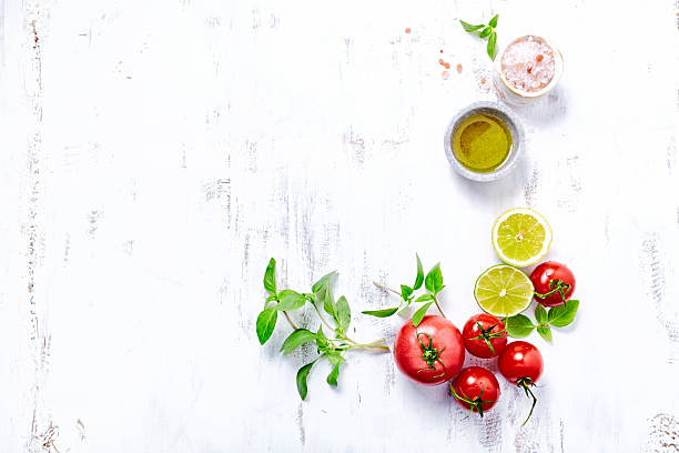 Tomatoes, Basil, Olive Oil and Himalayan Salt An arrangement of tomatoes, basil, salt, olive oil, lime and lemon on a wooden background lime basil plant stock pictures, royalty-free photos & images