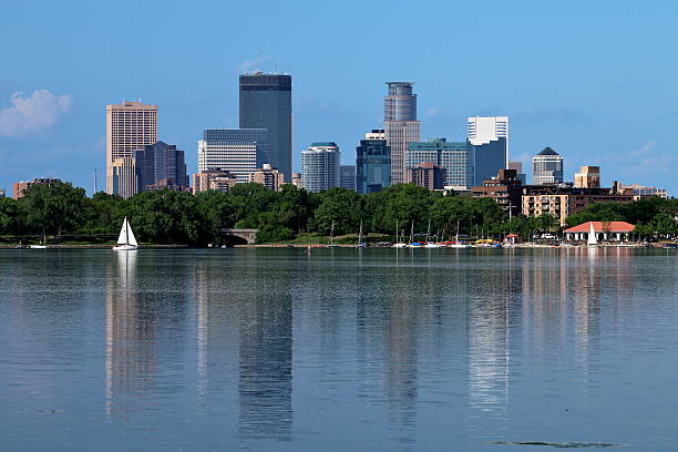 Minneapolis Skyline Reflecting in Lake Calhoun Downtown Minneapolis reflecting in Lake Calhoun including a sail boat and the marina with several moored sail boats. minneapolis stock pictures, royalty-free photos & images