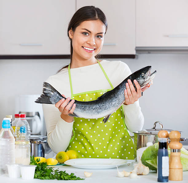 istock Attractive brunette girl preparing trout dish 538065836