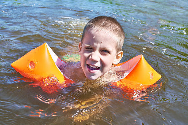 istock Little boy swimming in river 538066080