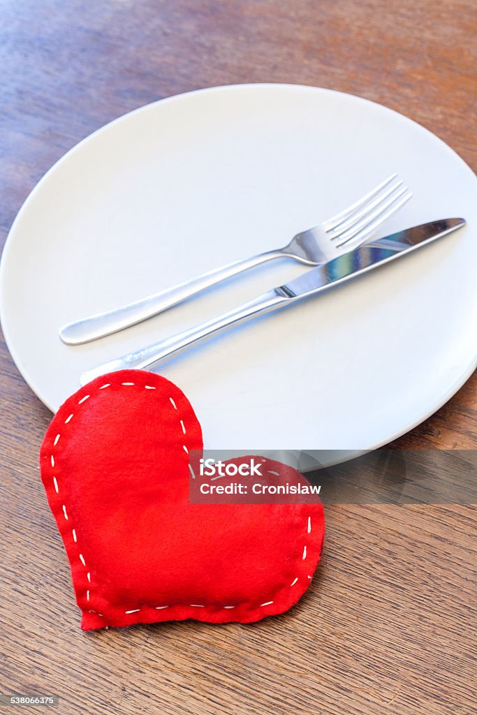 Valentine's Day - Hand made red heart with cutlery background. Valentine's Day - Hand made red heart with cutlery in the background. 2015 Stock Photo