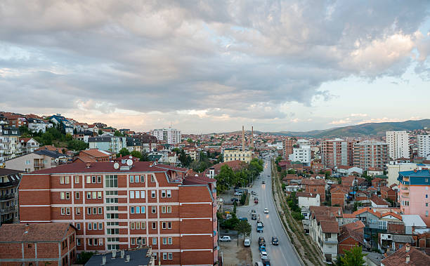 Skyline in Pristina, Kosovo Traffic drives along a city street at sunset in the capital of Kosovo. pristina stock pictures, royalty-free photos & images