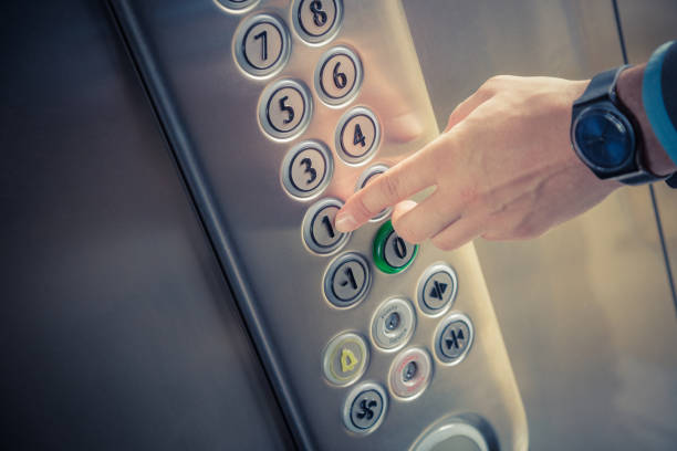 мужской палец, нажимаемый на кнопку первого этажа в лифте - elevator push button control panel moving up стоковые фото и изображения