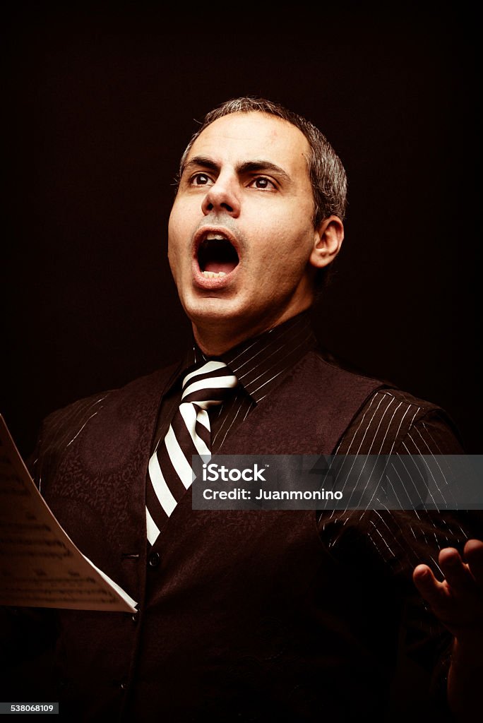 Opera singer mature man singing opera on black background Opera Stock Photo
