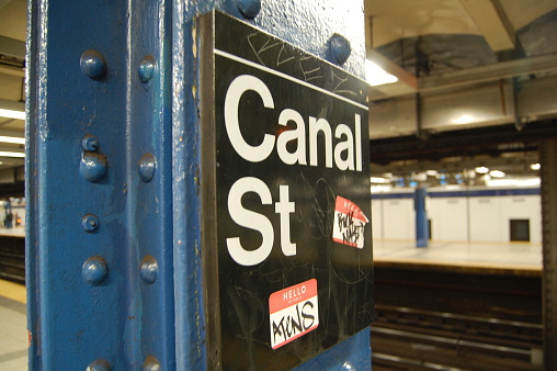 Black MTA subway platform sign for Canal Street, with Graffiti and stickers.