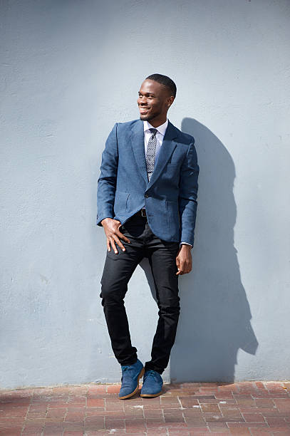 istock Smiling business man standing against gray background 538070331