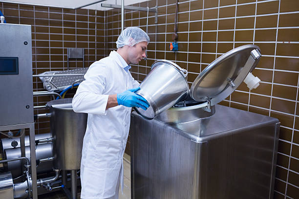 istock Smiling man in lab coat pouring something on the machine 538082581
