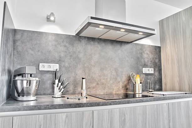 New modern gray kitchen with utensils Home interior, new, modern, sparse and luxury kitchen gray furniture with some kitchen utensils, shot in front of the cooking area, hob with range hood, extractor fan. kitchen hood stock pictures, royalty-free photos & images