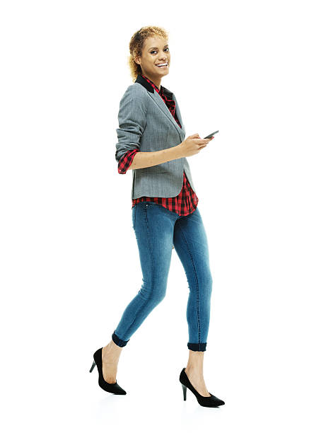 istock Cheerful casual woman using mobile & walking 538082879