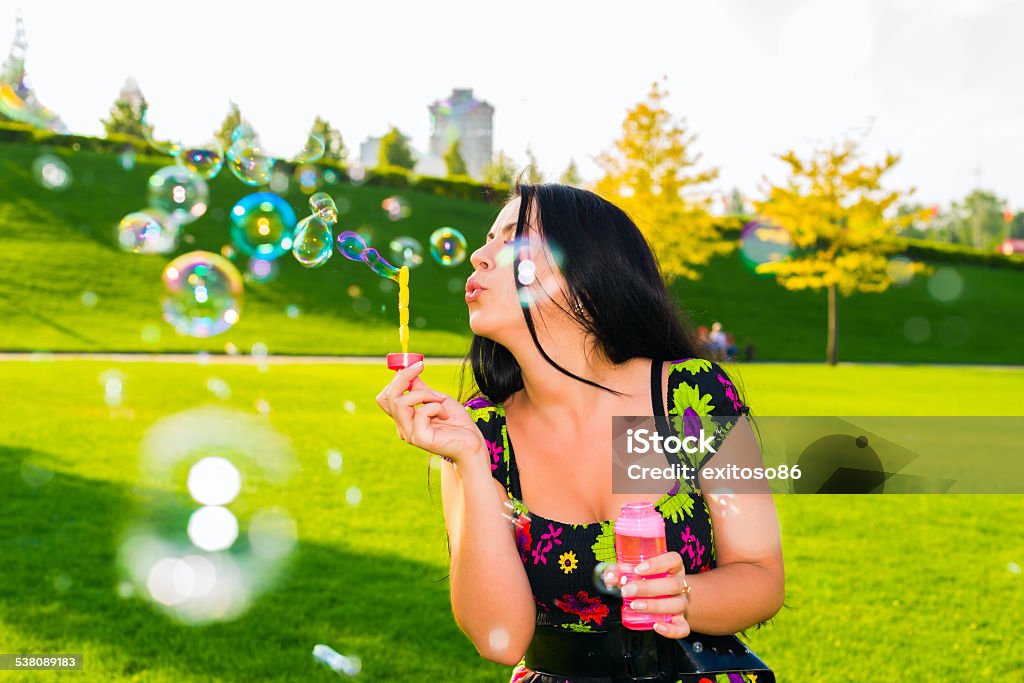 Girl with soapy bubbles Young happy girl blowing soap bubbles on the lawn on green grass and having fun 2015 Stock Photo