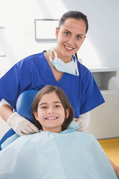 istock Pediatric dentist putting on her young patient the scrubs 538099873
