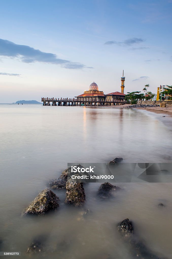 Malaysian Mosque with Water Reflection Malaysian mosque located in Perlis Malaysia, named Masjid Al-Hussein, also called floating mosque. This is a beautiful places for tourist. The sunset is behind the mosque from the front view. 2015 Stock Photo