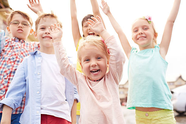Excited little friends Excited children raising their arms childrens day photos stock pictures, royalty-free photos & images