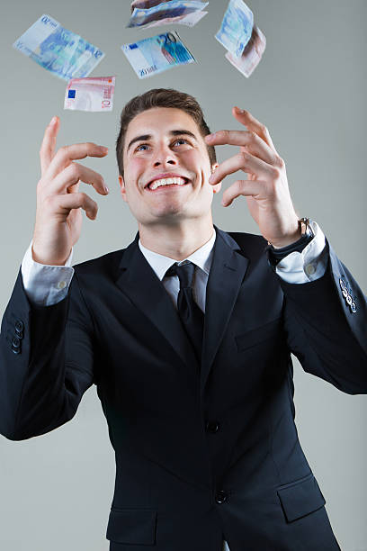 istock Young man in formalwear throwing money. 538123107