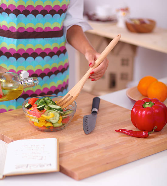 istock Smiling young woman  mixing fresh salad 538123267