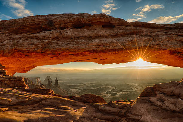 Mesa Arch Dawn Sunburst Sunburst under Mesa Arch, with the arches and landscape of Canyonlands National Park appearing under the arch valley photos stock pictures, royalty-free photos & images