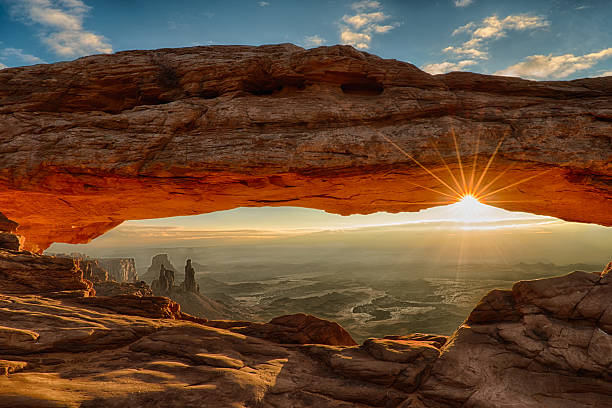 Mesa Arch Dawn Sunburst Sunburst under Mesa Arch, with the arches and landscape of Canyonlands National Park appearing under the arch natural arch stock pictures, royalty-free photos & images