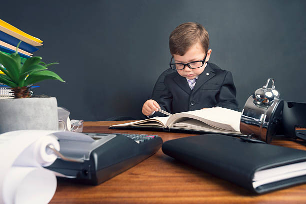 istock Young boy dressed in suit working at desk. 538143859