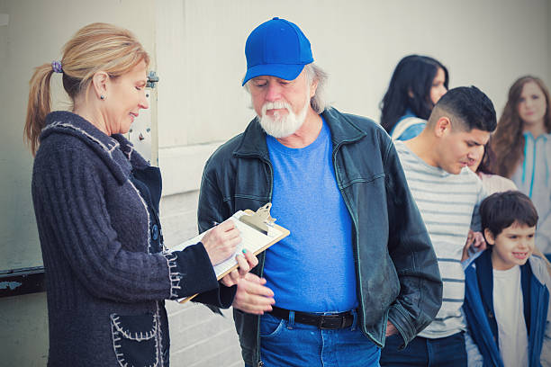 desalojados pessoas e famílias precisa s'inscrever para obter ajuda. - homelessness food in a row people - fotografias e filmes do acervo