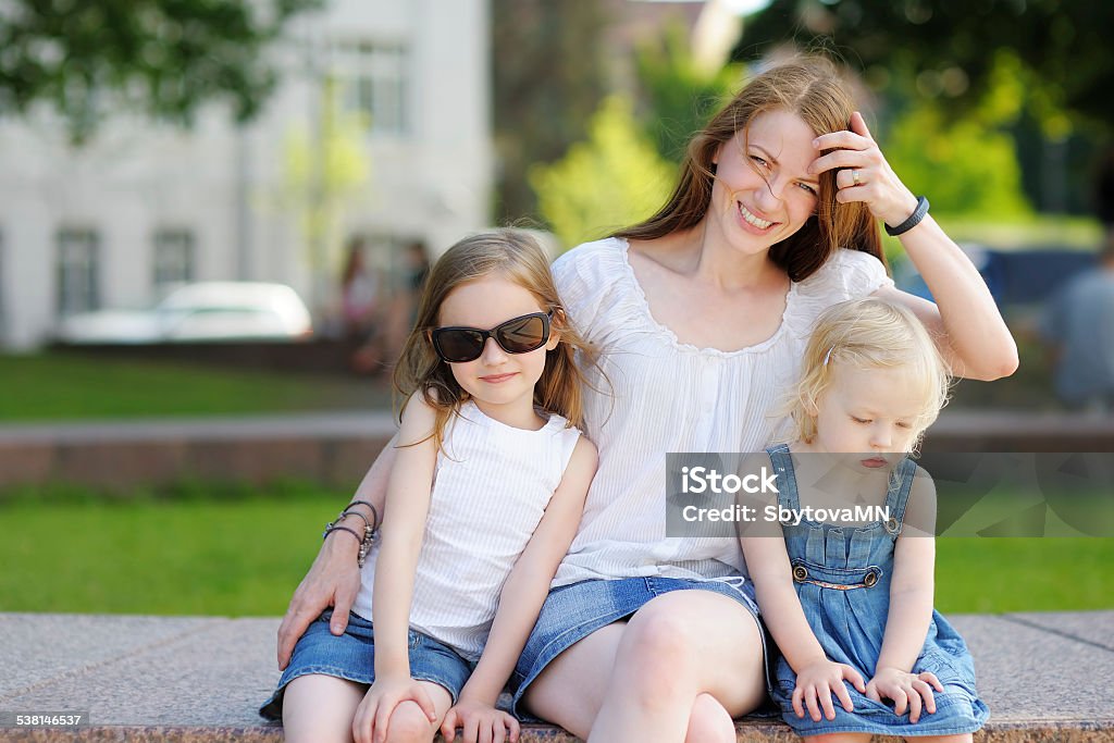 Young mother and her daughters Young mother and her daughters outdoors at summer Child Stock Photo