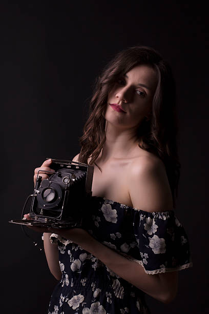 istock Pretty brunette woman with retro camera in the shadows 538154890