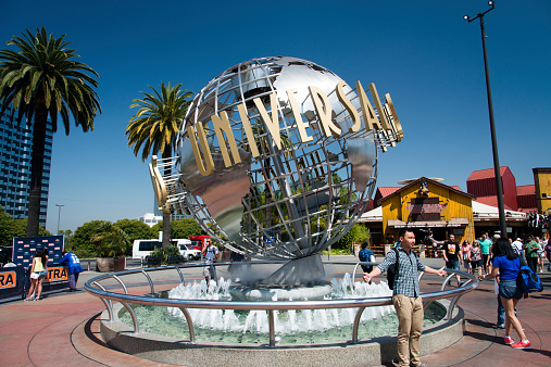 Los Angeles, California, USA - May 27, 2014: Universal Studios Hollywood globe outside the theme park entrance with visitors enjoying during a sunny day.