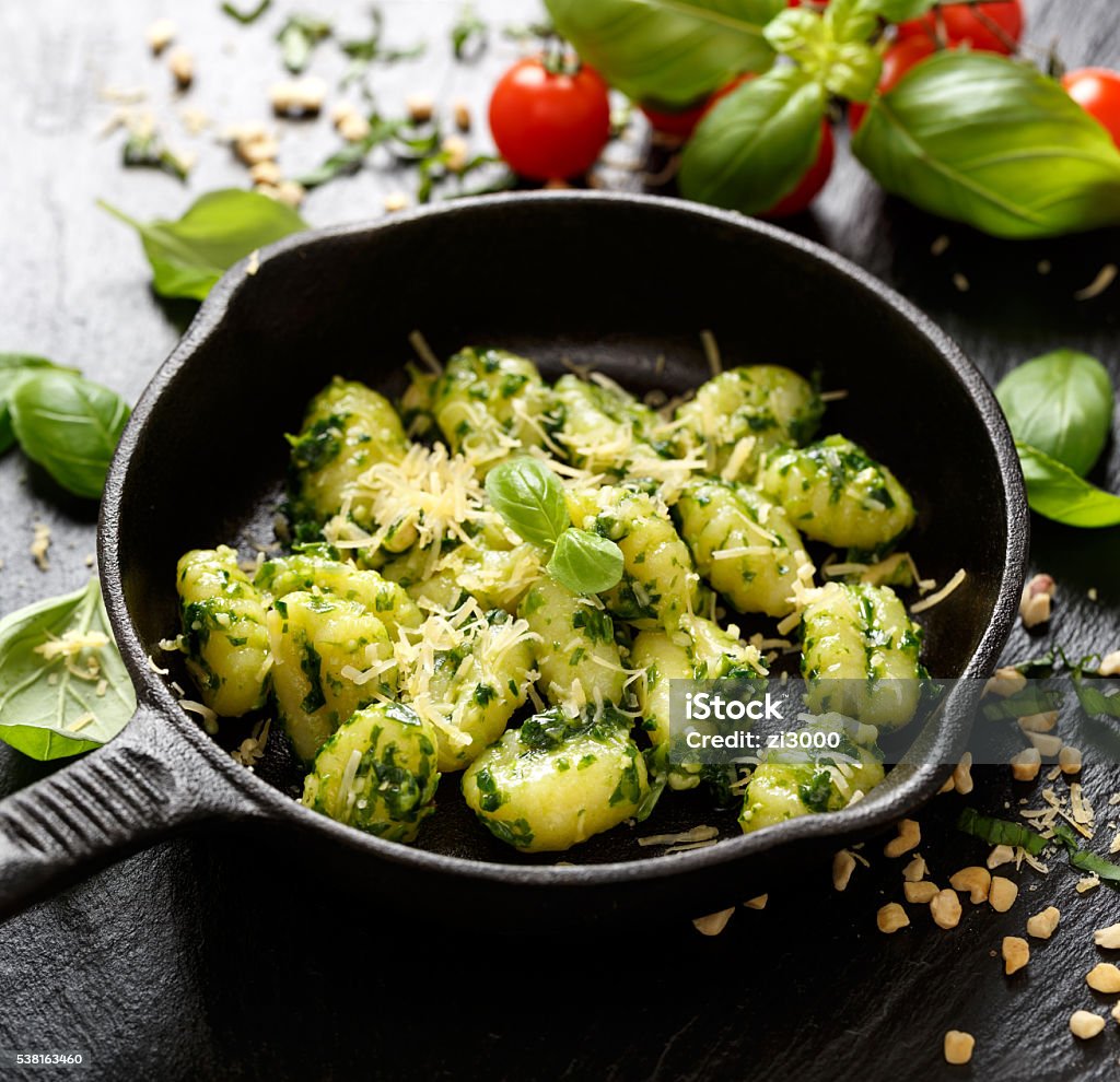Gnocchi with herb pesto, delicious Italian vegetarian dish Potato gnocchi with herb pesto and cheese on a pan Gnocchi Stock Photo